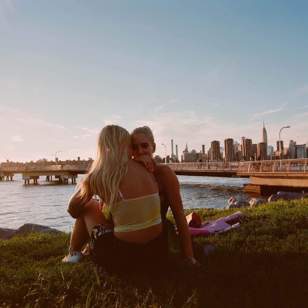 Female couple looking watching a sunset by the ocean.