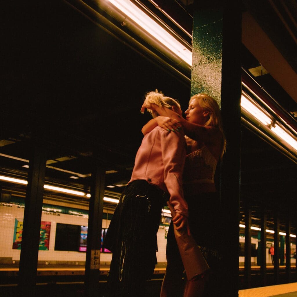 Married couple about to kiss while waiting for a subway.